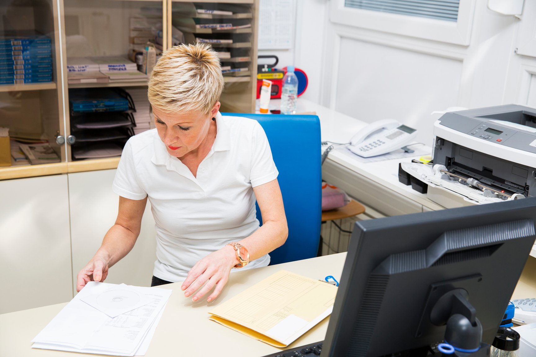 Nurse in her office,working with computer,making paperwork